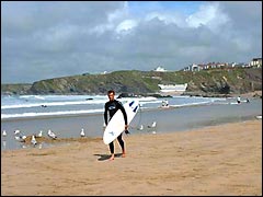 Newquay surfer with board on Towan beach